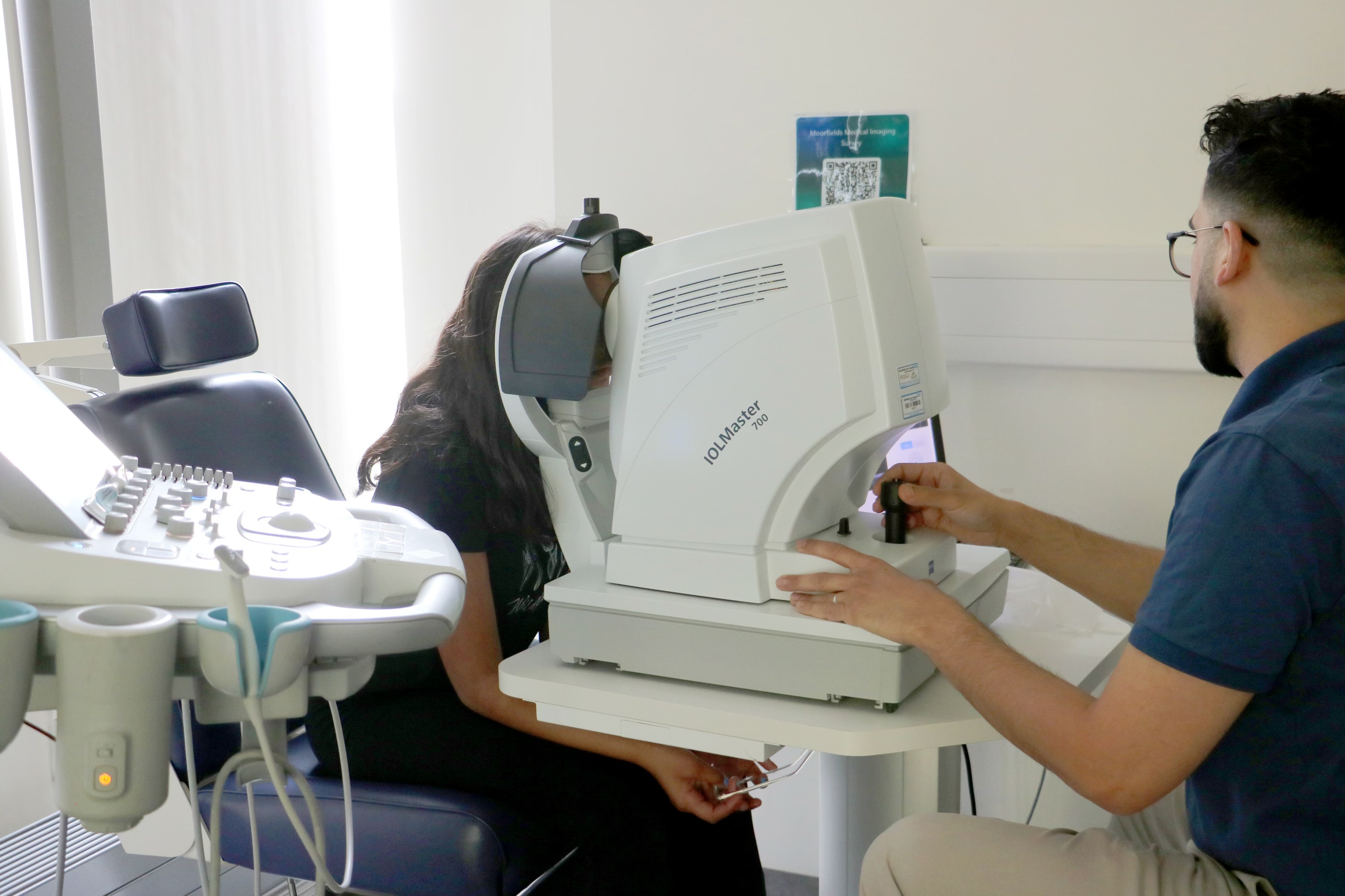 Consultant conducting an eye test on a young person in a hospital consultation room