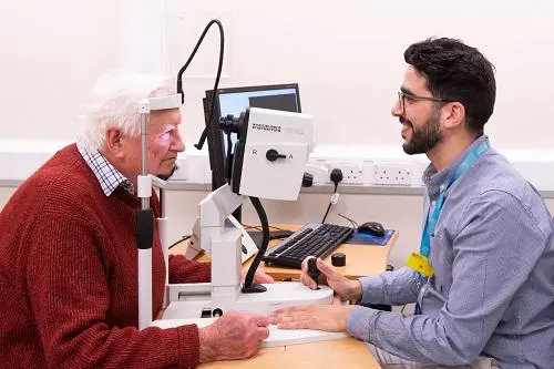 Patient having their eyes examined, using ophthalmological technology, by a consultant
