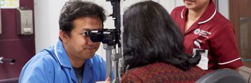 A nurse performs an eye exam