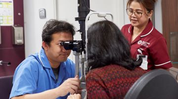 A nurse performs an eye exam