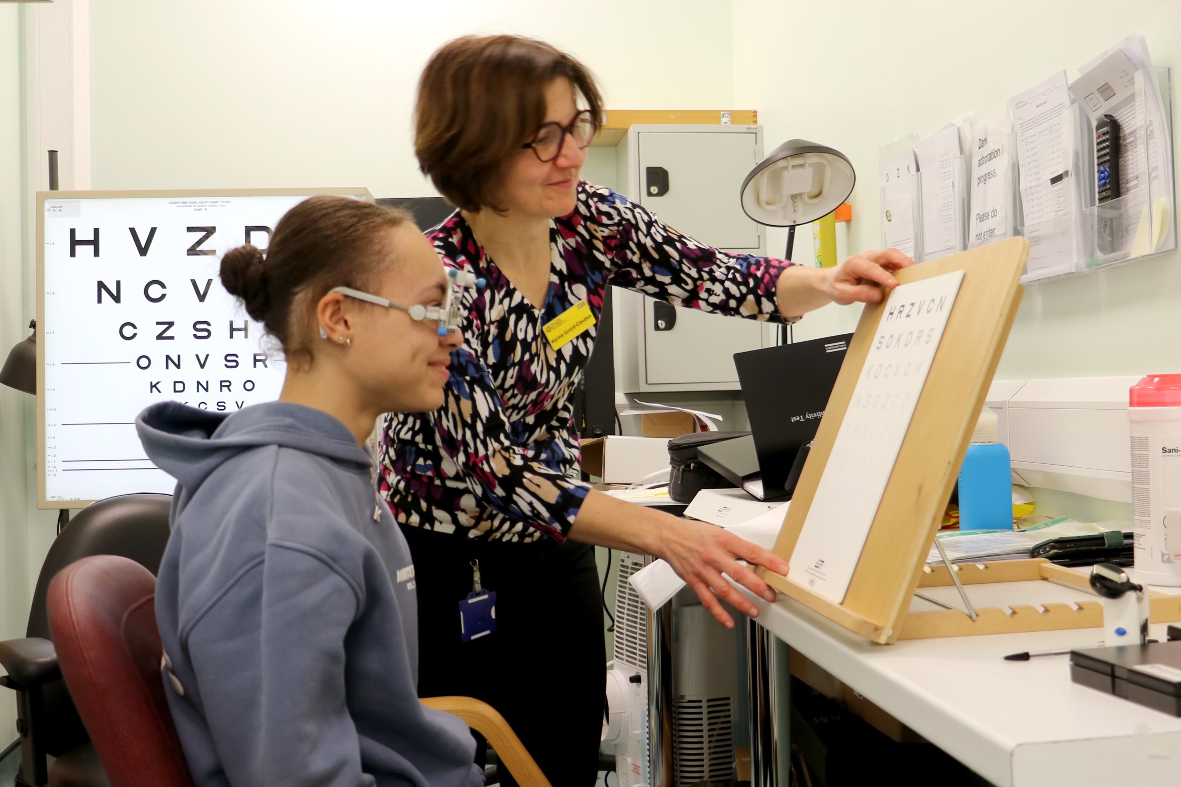Consultant conducting an eye test on a young person in a hospital consultation room