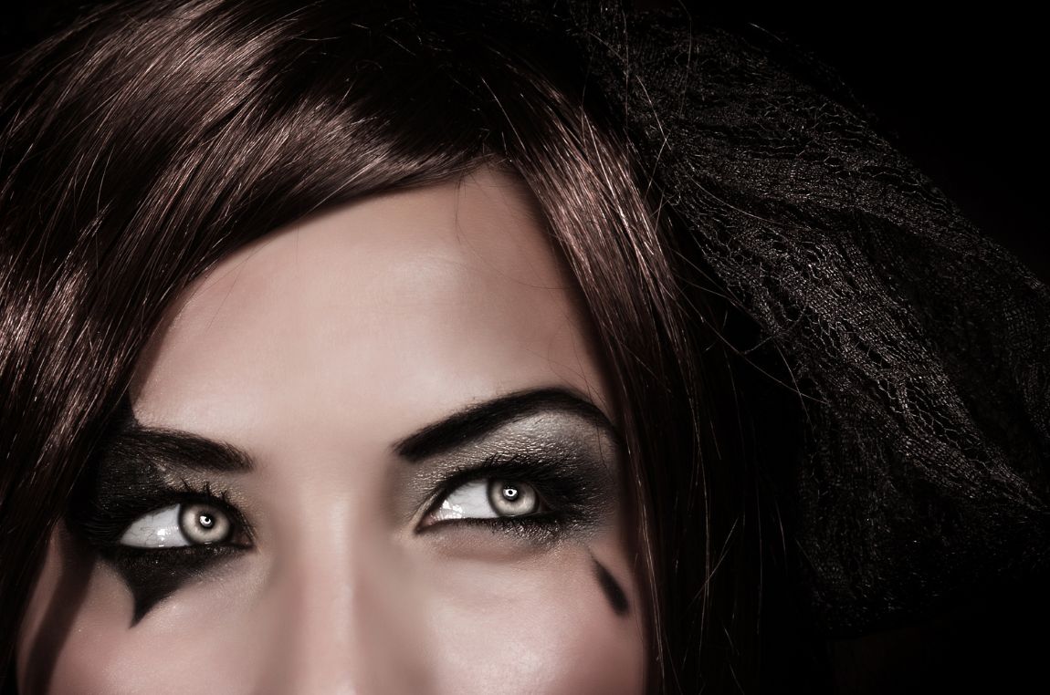 A young woman’s eyes with a Halloween themed make-up and wearing cosmetic contact lenses.