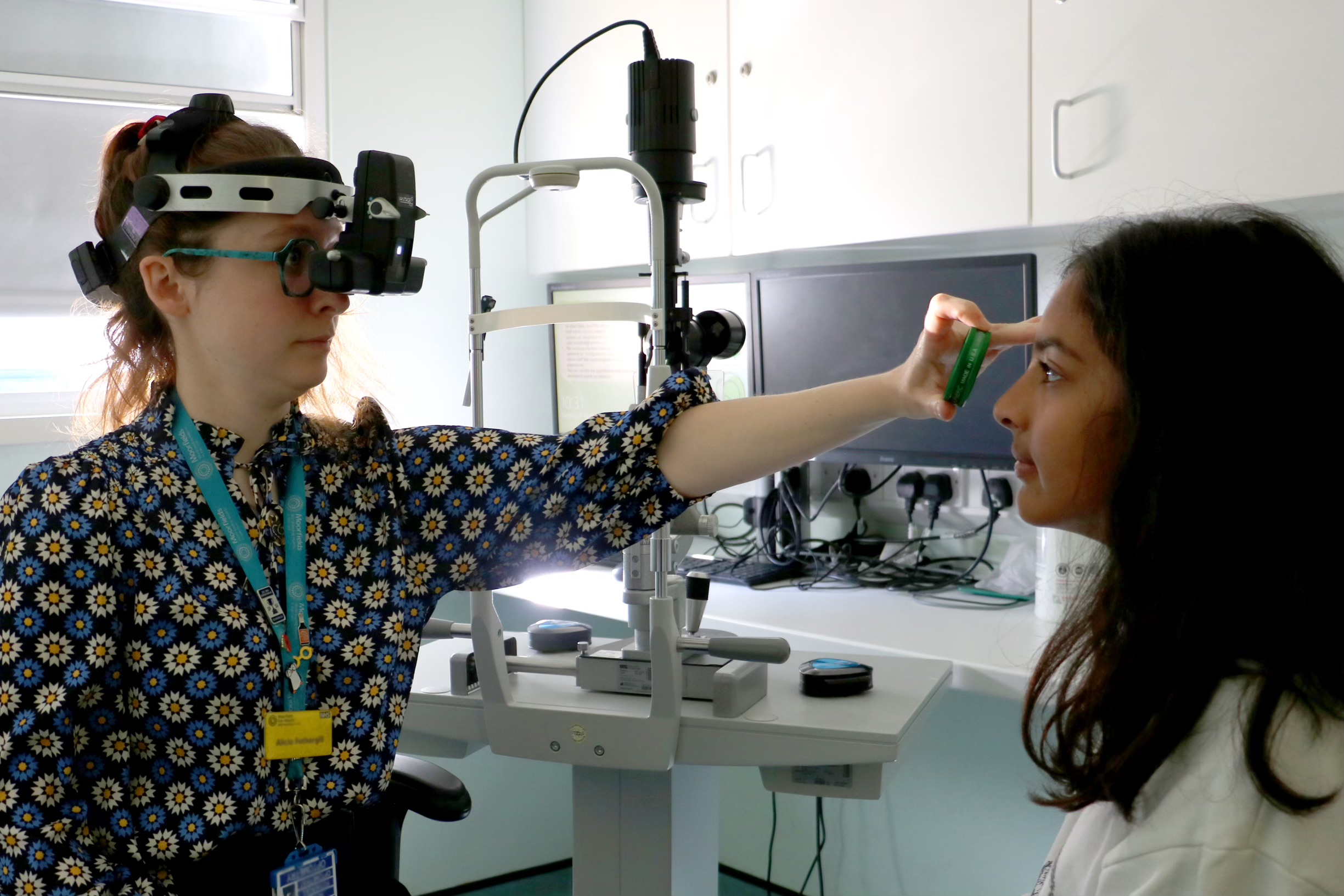 Consultant conducting an eye test on a young person in a hospital consultation room