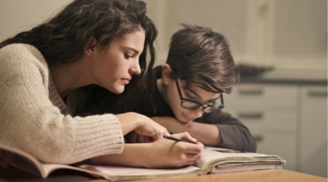 Mother and son writing in a book