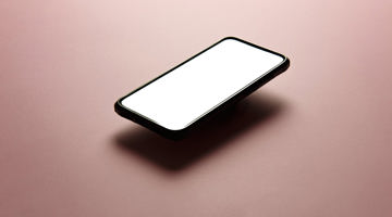 Black mobile phone on pink background