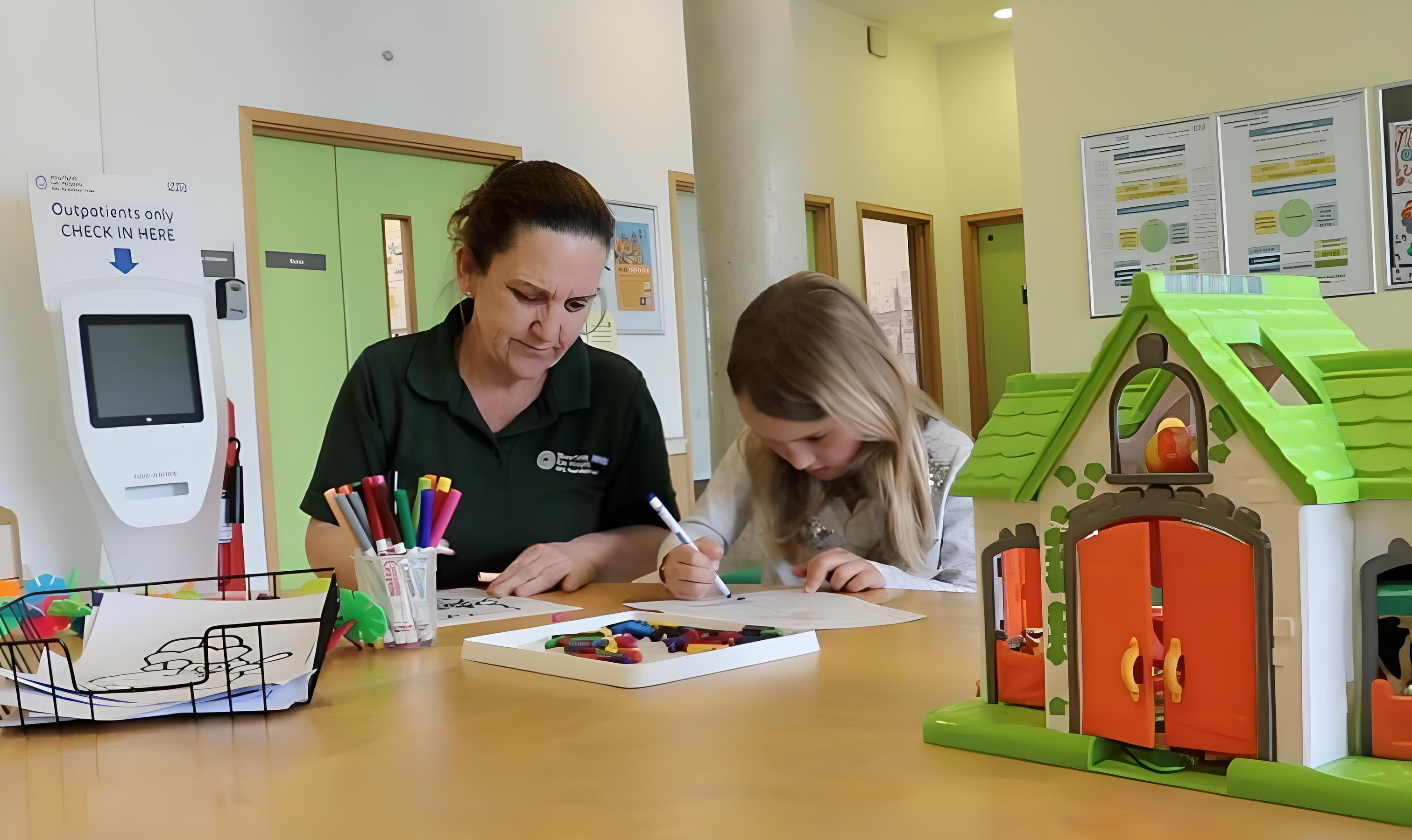  A health play specialist supporting a colouring activity