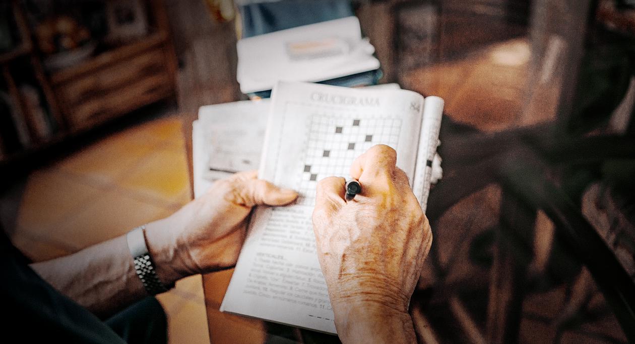 A mature person doing word puzzles.
