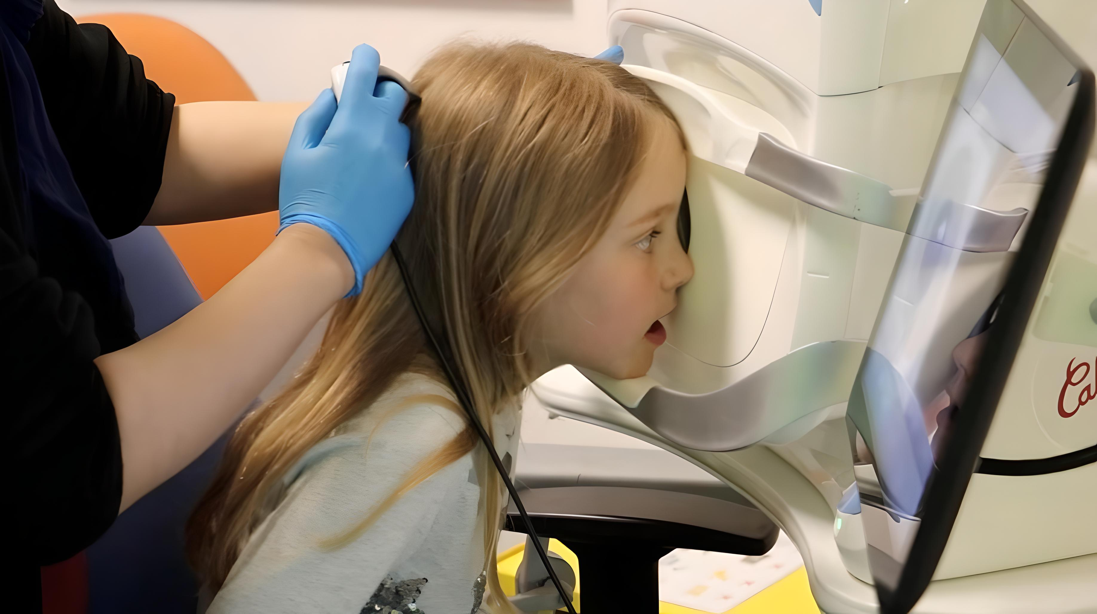 Young person looking into an eye test machine